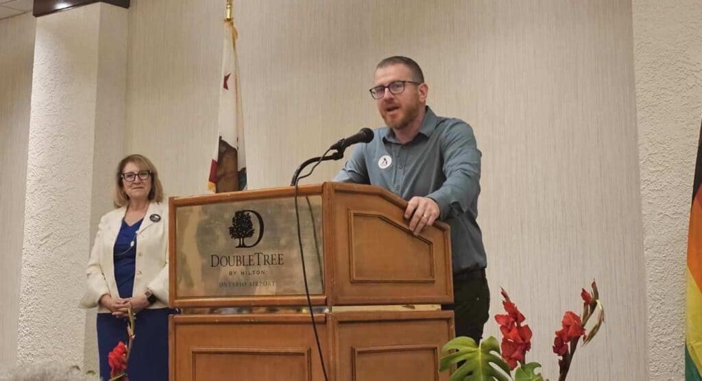 beau mcfarland speaking behind a podium wearing a dress shirt promoting his candidacy for chino valley school board in trustee area 2